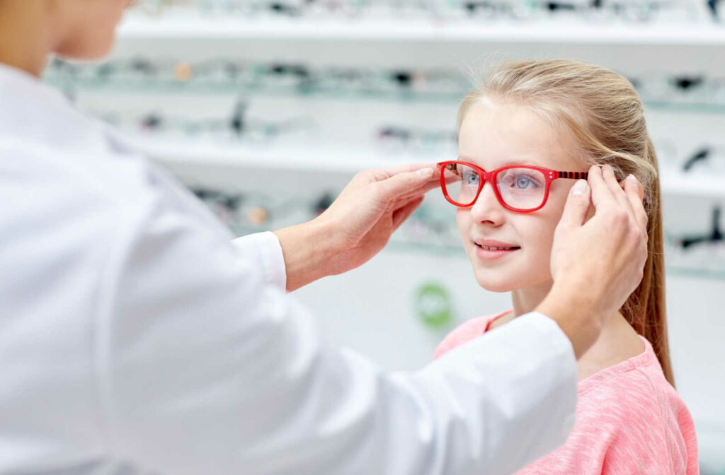 An optician fits a young girls with myopia management glasses to help slow the progression of her refractive error.