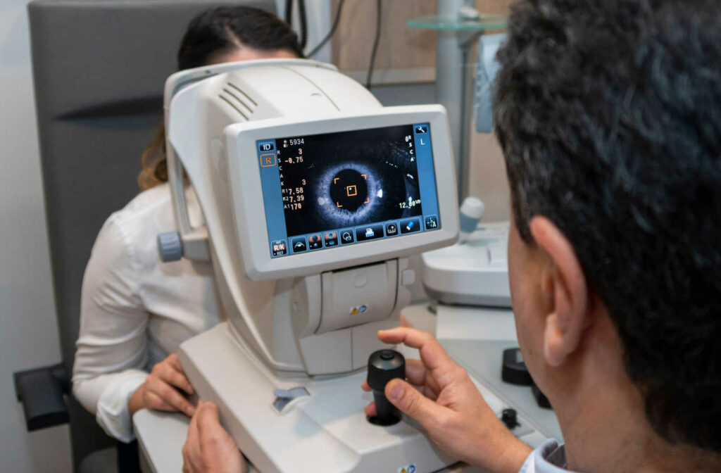 An eye doctor using an optos retinal imaging instrument to scan a female patient's eye.