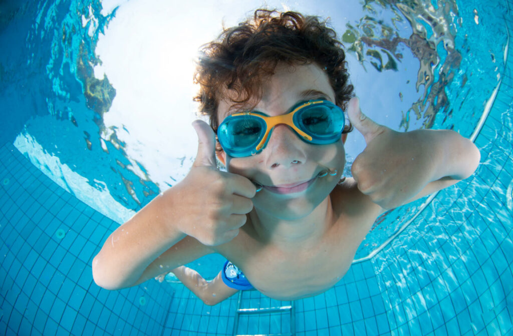 A boy is wearing safety goggles while swimming underwater to protect his eyes.