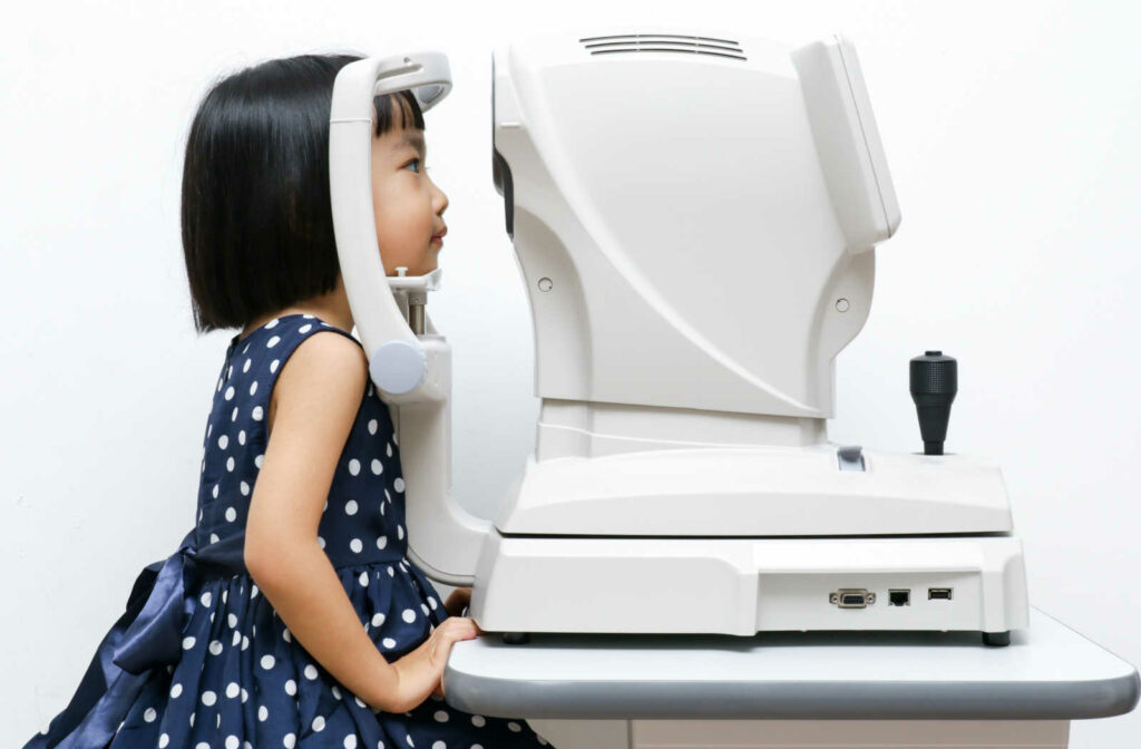 A small girl sitting in front of an OCT for an eye checkup.