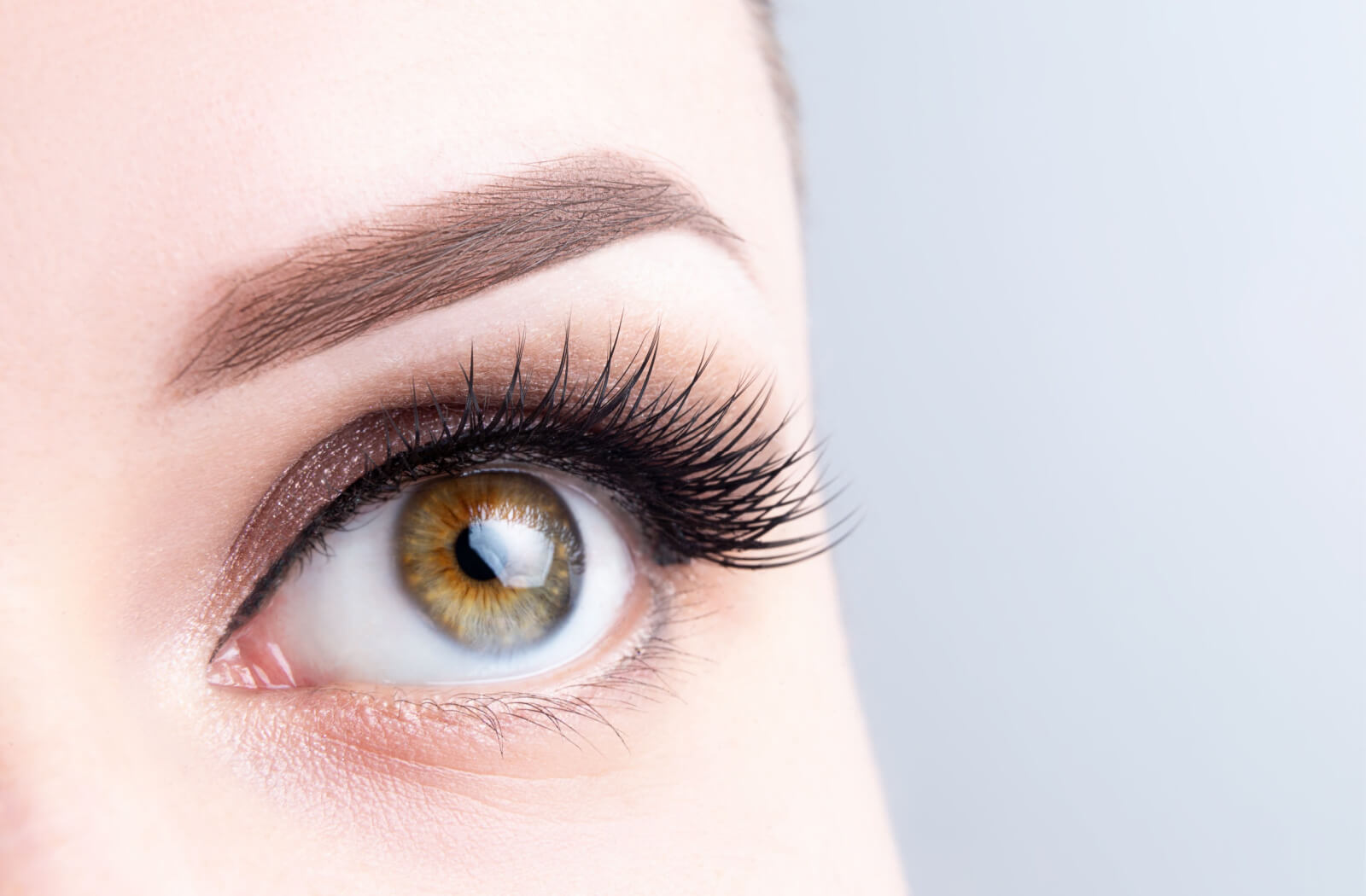 A young woman with hazel eyes and eyelash extension.