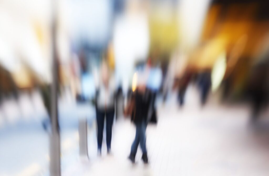 Blurry vision of pedestrians on a busy street illustrating visual impairment caused by dry eyes or other vision-related conditions