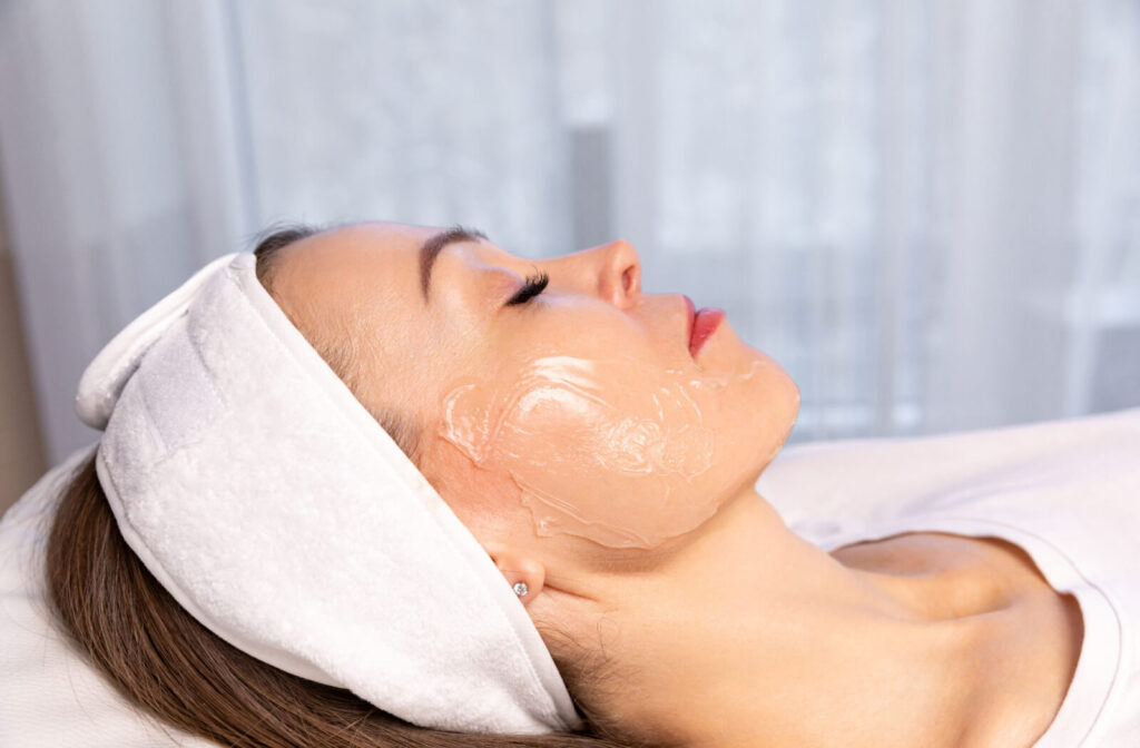 A patient lying down during a skin tightening treatment with cooling gel applied to their face.