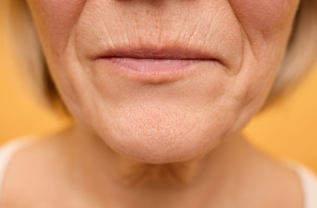 Close-up of a mature woman's lower face showing natural skin texture and smile lines.
